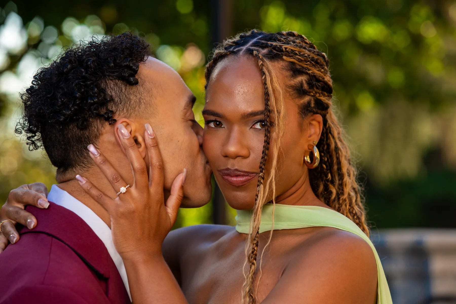 Gary kissing Alexis on the cheek while she shows her engagement ring