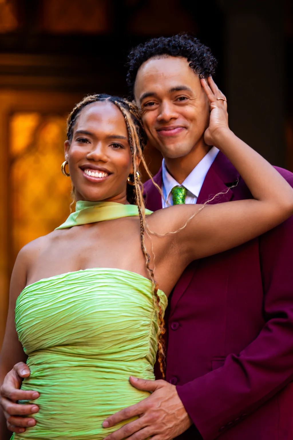 Alexis and Gary smiling together, wearing sage and merlot