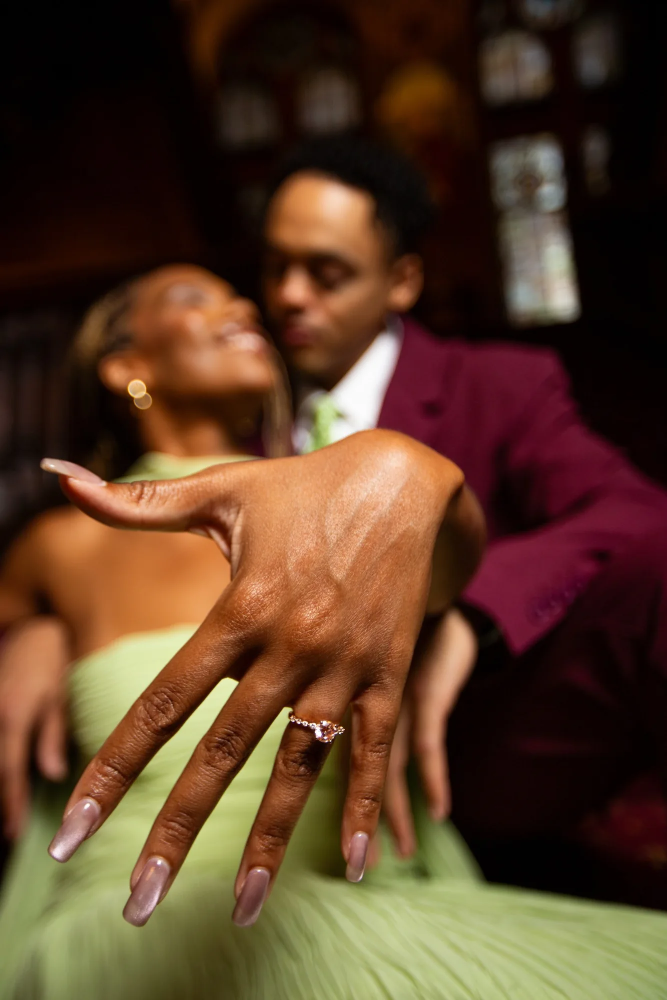 Alexis holding her engagement ring toward the camera with Gary behind her
